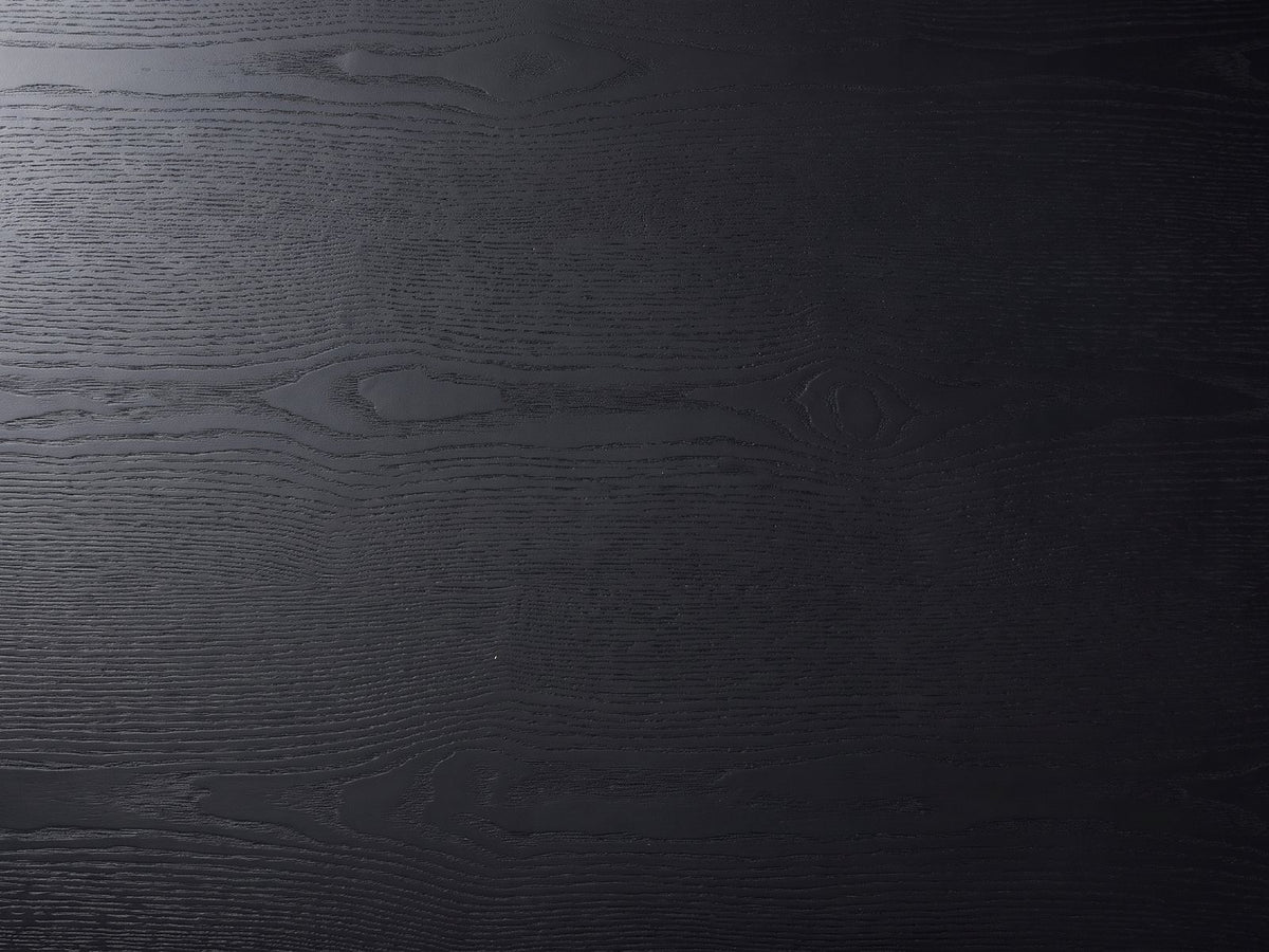 Close-up of the Monterosso Black Wood Veneer Fluted Oval Coffee Table: the open grain of the matte black top