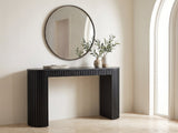Monterosso Black Wood Veneer Fluted Oval Console Table under a round mirror in a travertine entryway