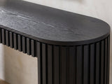Close-up of the Monterosso Black Wood Veneer Fluted Oval Console Table: the thin black top over the slatted apron and a slatted end
