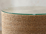 Close-up of the Montescaglioso Woven Seagrass Drum Side Table: the glass top resting on the coiled seagrass rope