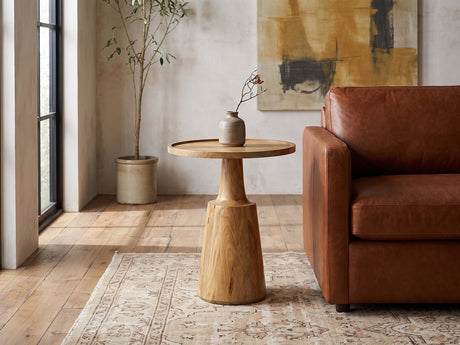 Montisi Natural Mango Pedestal Side Table beside a leather sofa in an industrial loft