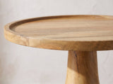 Close-up of the Montisi Natural Mango Pedestal Side Table: the raised rim of the round mango tray top