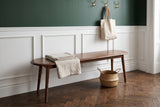 Montone bench in a Brooklyn brownstone entry hall with a deep green wall, white wainscot panelling, a herringbone floor and a seagrass basket