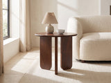 Morciano Mango Wood Round Side Table with a lamp and a ceramic bowl beside a cream boucle armchair in a bright plaster room