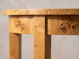 Close-up of the Mottola Mappa Burl Half-Moon Console Table: a square leg meeting the curved burl apron under the top