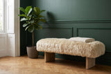 Narni sheepskin bench against a forest-green panelled wall in a Brooklyn brownstone entry with a herringbone oak floor and a fiddle-leaf fig (plant and throw not included)