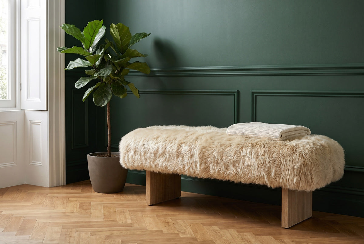 Narni sheepskin bench against a forest-green panelled wall in a Brooklyn brownstone entry with a herringbone oak floor and a fiddle-leaf fig (plant and throw not included)