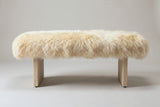 The Narni bench in natural blonde sheepskin, front view on a light studio backdrop