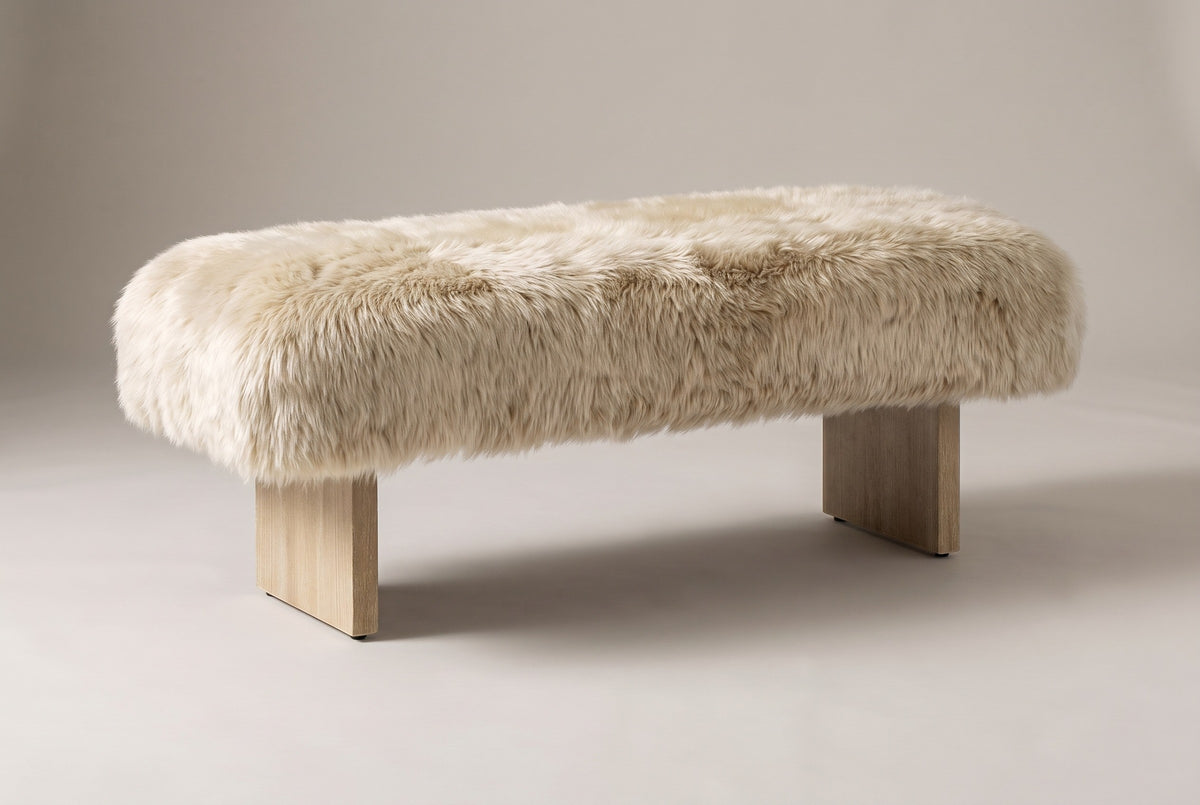 The Narni bench in natural blonde sheepskin, three-quarter view on a light studio backdrop