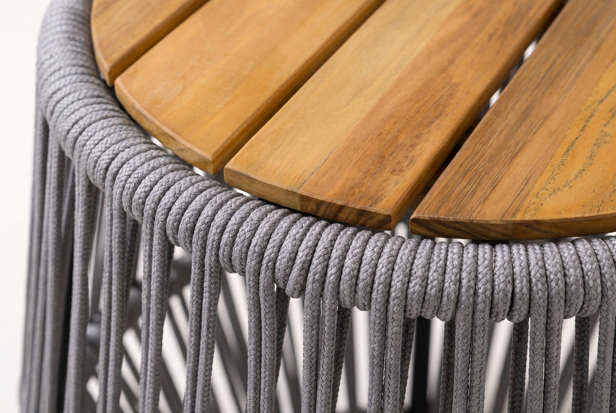 Close-up of the acacia slats in a natural teak finish and the grey braided rope rim of the Naro side table