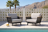 Two Naxos accent chairs on pale terrazzo beside a pool in Palm Springs, a white breeze-block wall, palms and mountains behind (bowl not included)