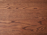 Close-up of the Neive 47-Inch Oval Walnut-Stained Solid Oak Coffee Table with 2 Drawers: the walnut-stained oak grain of the top
