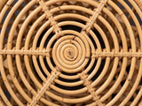 Close-up of the Neviano Natural Rattan Hourglass Side Table: the concentric rattan rings of the open top