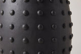 Close-up of the matte black lightweight concrete and the round studs on the Nicolosi side table