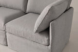 A Nicosia corner module up close: the low slim arm, the corner throw pillow, the seat cushion and the slipcover skirt