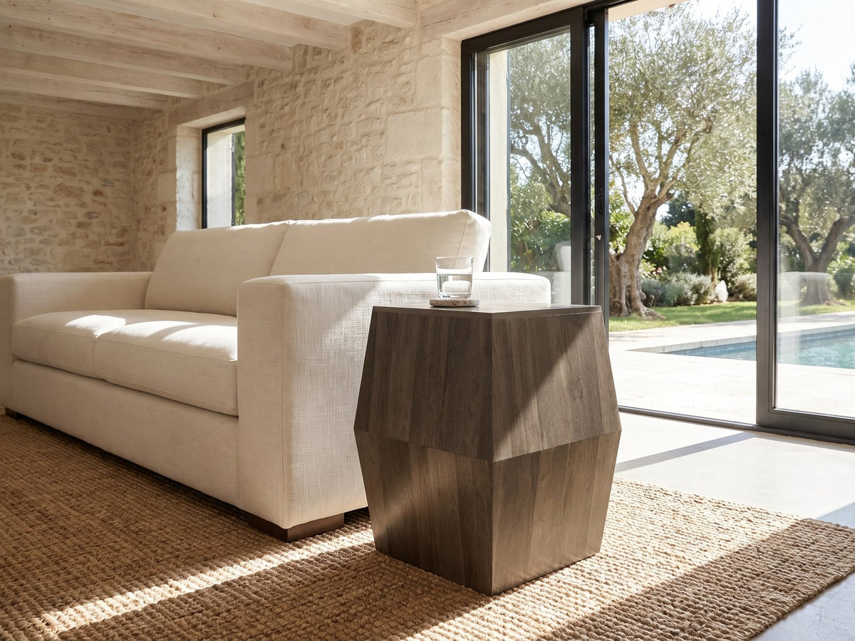 Nicotera Ash Grey Mango Faceted Side Table beside a linen sofa in a poolside villa