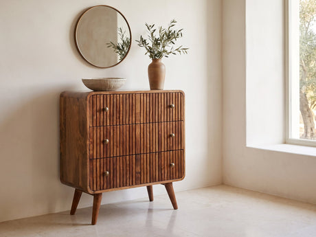 Noale 28-Inch Honey Caramel Solid Mango 3-Drawer Chest under a round bronze mirror in a villa bedroom