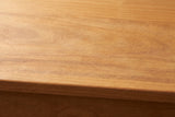 Close-up of the honey pine on the Noci cabinet: soft grain with warm amber tones running to a square edge