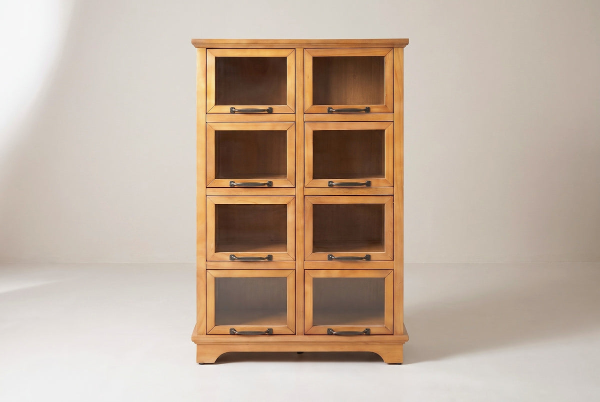 The Noci pine display cabinet in honey pine, front view on a light studio backdrop