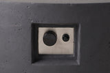 Close view of the Noto fire pit's control niche: a recessed niche in the concrete side wall with a brushed steel plate, one control knob and one push button