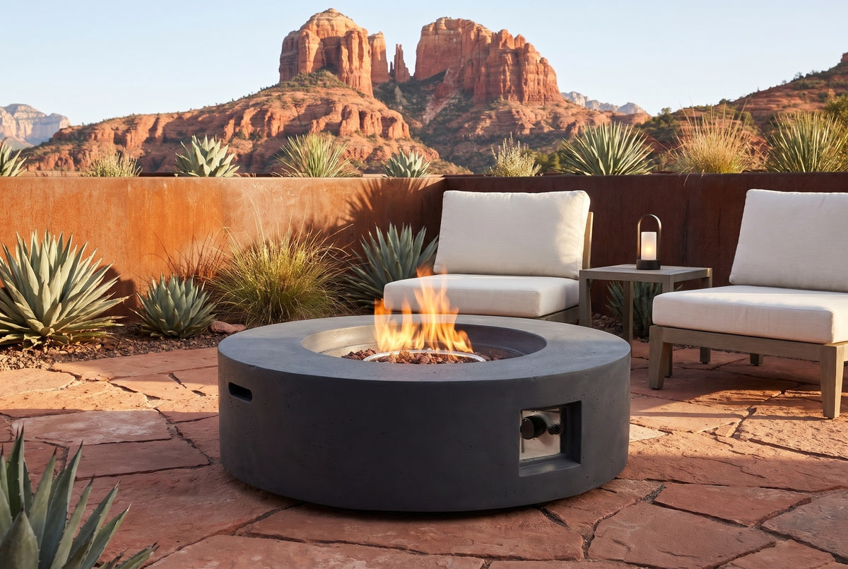 Noto fire pit lit on a red sandstone patio in Sedona, Arizona, a rust corten wall, agaves and the red rock buttes behind (chairs, side table and lantern not included)