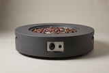 The Noto fire pit seen straight from the front: the round drum, the control niche in the middle of the side wall and the low base