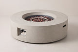 The Noto round fire pit in light gray concrete, three-quarter view on a light studio backdrop, with the control niche on the front and a handle slot in the side