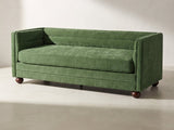 Novara Channel-Back Sofa in forest green against a plaster wall in morning light