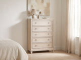Oderzo 36-Inch Washed Oak 5-Drawer Chest against a plaster wall under an abstract canvas in a bright bedroom