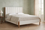 Ofena white boucle bed against a sage-green limewash wall in a Lisbon apartment bedroom with a tall window, a linen curtain and a herringbone floor