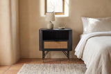 Olbia black acacia and rattan nightstand against a sand-coloured lime plaster wall in a Santa Fe bedroom with a deep-set window, terracotta tiles and a wool rug
