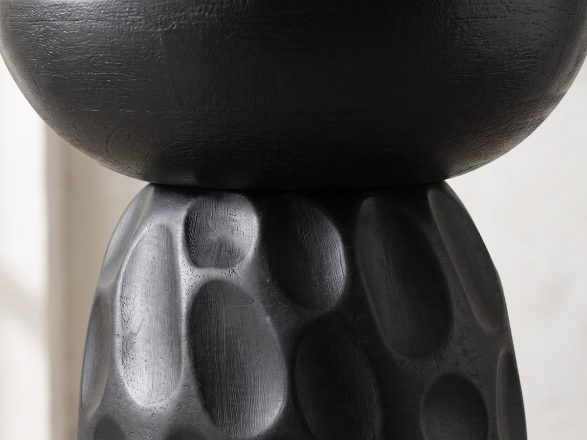 Close-up of the Olevano Carved Black Mango Pedestal Side Table: the smooth bowl-shaped top resting on the carved domed base