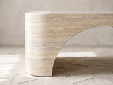 Close-up of the Orbetello Faux Travertine Oval Arch Coffee Table: the arch sweeping up from one end foot into the travertine-look band