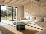 Orosei Verde Marble Coffee Table on a jute rug in front of a linen sofa in a poolside villa