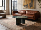 Orosei Verde Marble Coffee Table on a vintage rug in front of a leather sofa in an industrial loft