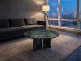 Orosei Verde Marble Coffee Table on a wool rug in front of a velvet sofa in a city penthouse at blue hour