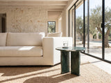 Orosei Verde Marble Round Side Table beside a linen sofa in a poolside villa