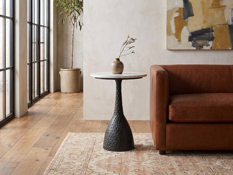 Orsara White Marble Pedestal Side Table beside a leather sofa in an industrial loft