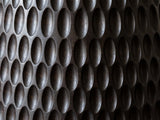 Close-up of the Orsomarso Carved Black Mango Pedestal Side Table: the hand-carved oval scoops of the black mango base