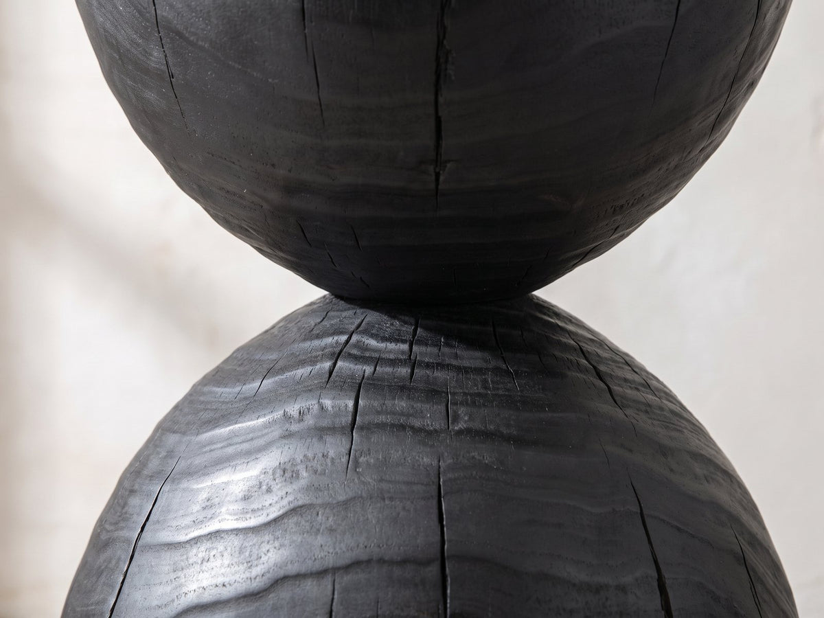 Close-up of the Orta Burnt Mango Hourglass Side Table: the narrow waist and the cracked charred grain of the lower dome