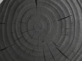 Close-up of the Orta Burnt Mango Hourglass Side Table: the growth rings and cracks of the end-grain top