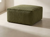 Orvieto Corduroy Cocktail Ottoman in olive green against a plaster wall in morning light
