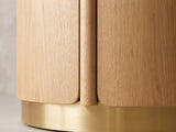 Close-up of the Ovada 35-Inch Round Sintered Stone and Wood Veneer Coffee Table: a rounded wood rail of the drum base meeting the brushed gold band