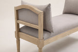 One end of the Paciano bench: the open arm with its arched top rail, greige panel and mid-rail, the corner block, the seat edge and a pillow leaning on the arm