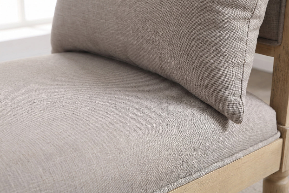 Close-up of the greige woven fabric on the Paciano bench seat and pillow, with the welt along the seat edge and a little of the pale wooden frame