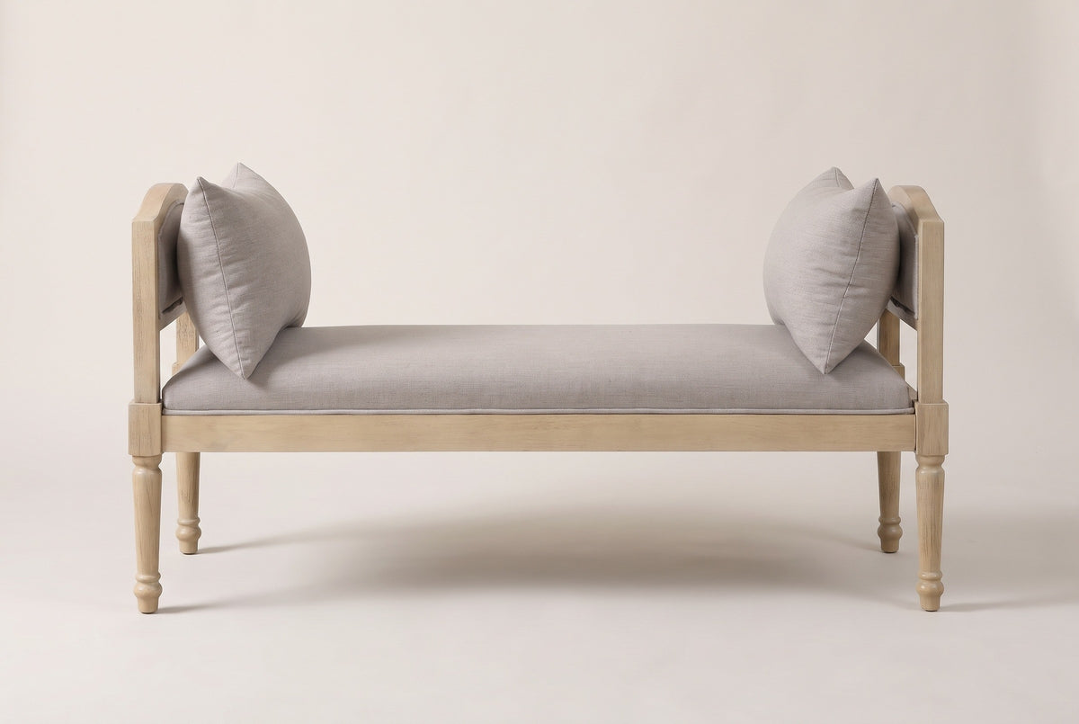 The Paciano bench in pale washed wood and greige fabric, straight front view on a light studio backdrop