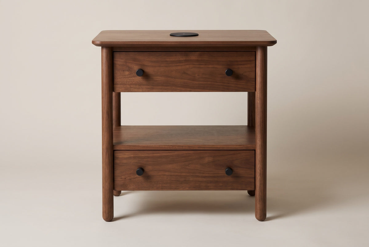 The Palau nightstand in warm brown solid neem, front view on a light studio backdrop: two drawers with black knobs, an open shelf and four round posts
