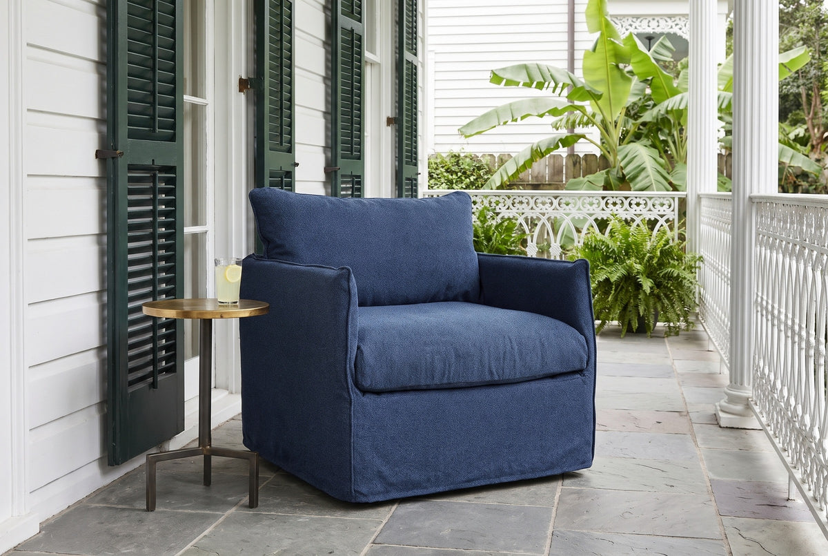 Palazzolo navy club chair on a slate-floored side gallery in the New Orleans Garden District, with green louvered shutters and a white cast-iron railing (side table not included)