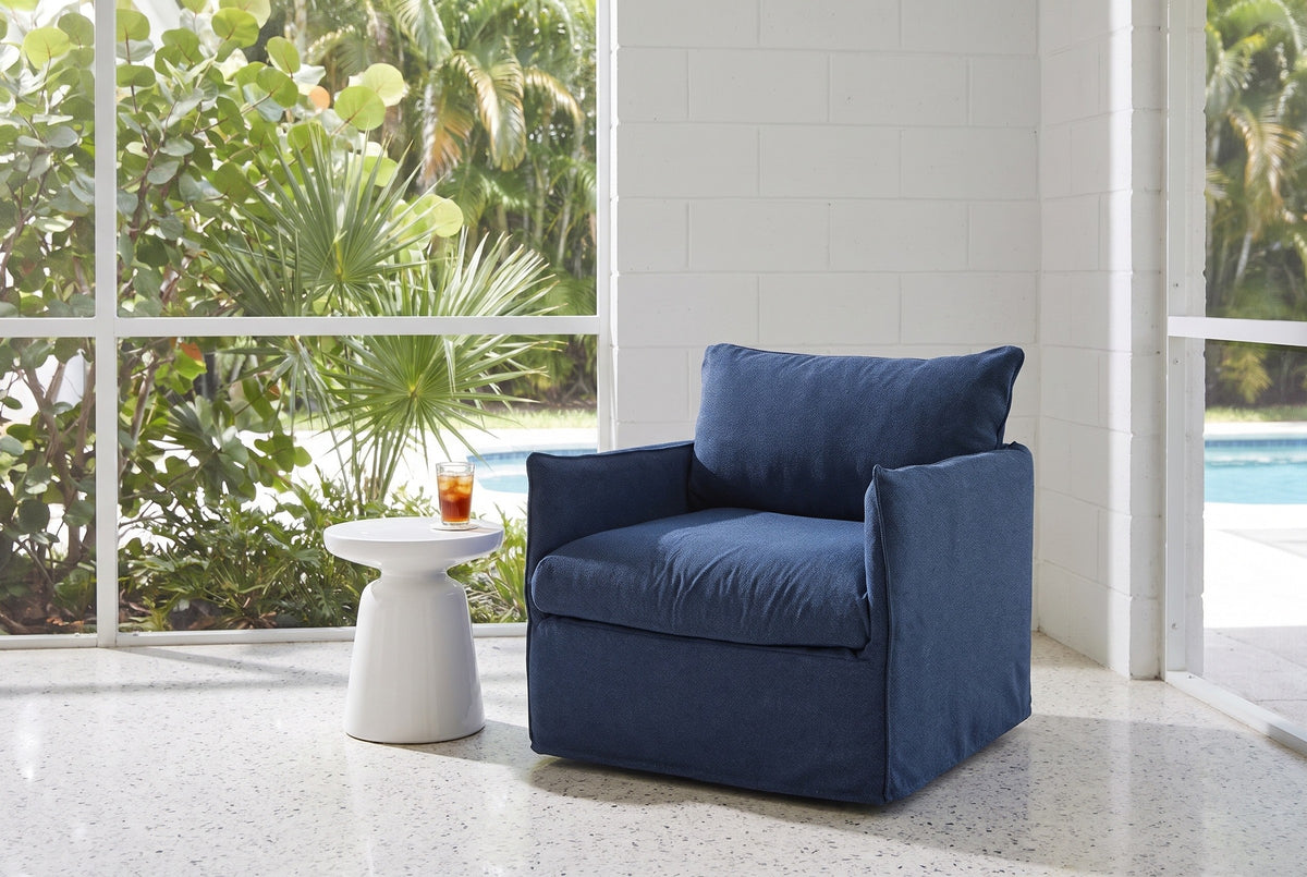 Palazzolo navy club chair in a mid-century Sarasota lanai with a white block wall, a terrazzo floor and a pool beyond the screen (side table not included)