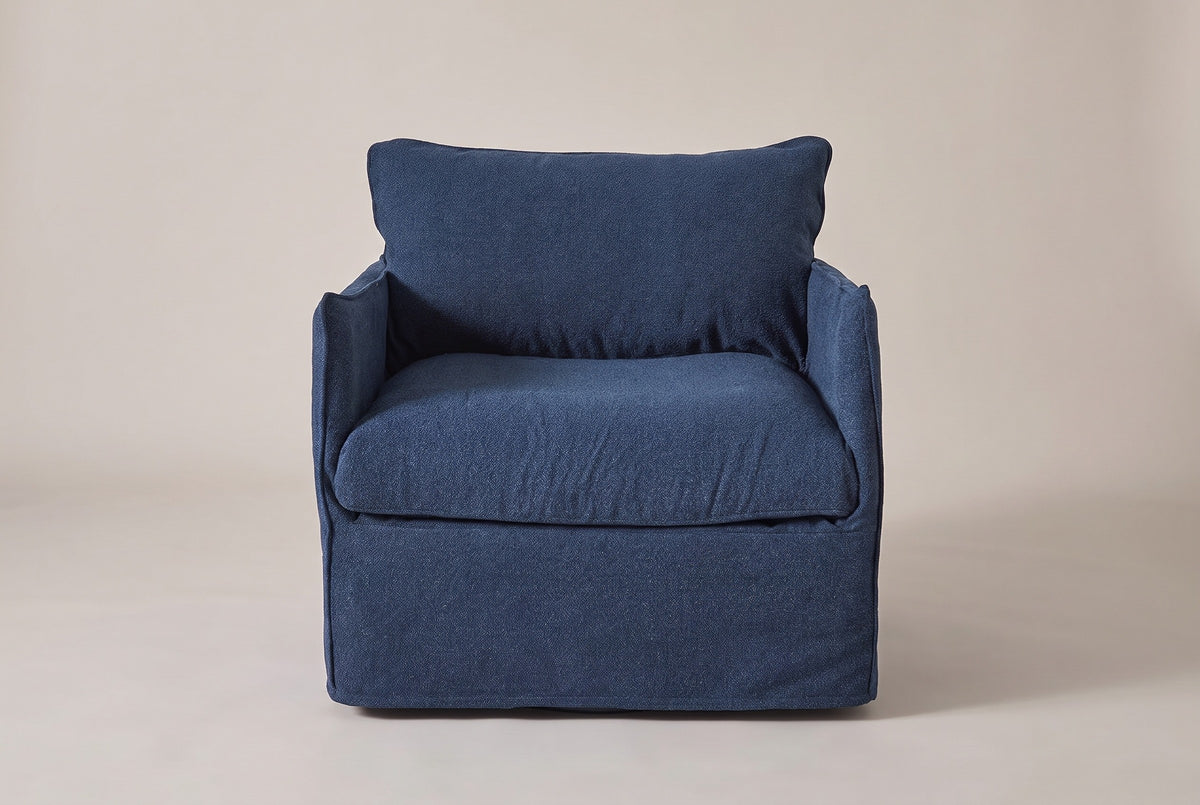 The Palazzolo club chair seen straight from the front: two slim arms, the back pillow and the skirt to the floor